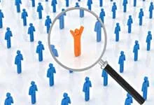 A magnifying glass highlights an orange figure with raised arms among many blue figures. The image conveys uniqueness and individuality