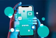 Hands hold a smartphone emitting digital icons, like video and settings, against a dark blue background, conveying a futuristic technology theme.